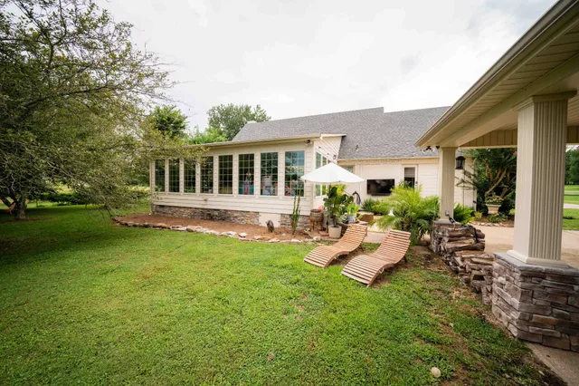 a view of a house with backyard sitting area and garden
