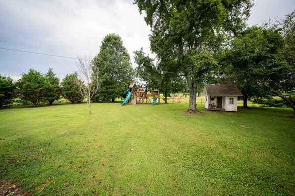 a view of yard with swimming pool and green space