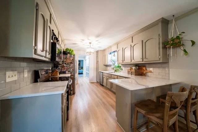 a kitchen with stainless steel appliances granite countertop a stove a sink and a microwave