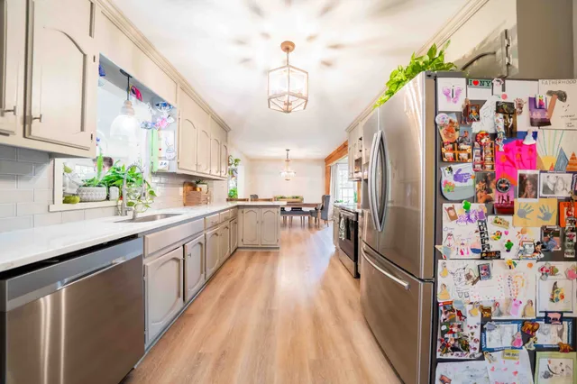 a living room with furniture a potted plant and a large window