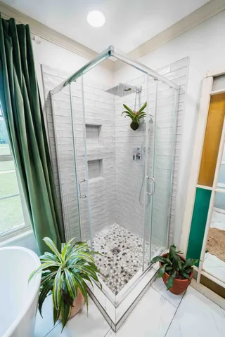 a bedroom with a bed a lamp and a large window