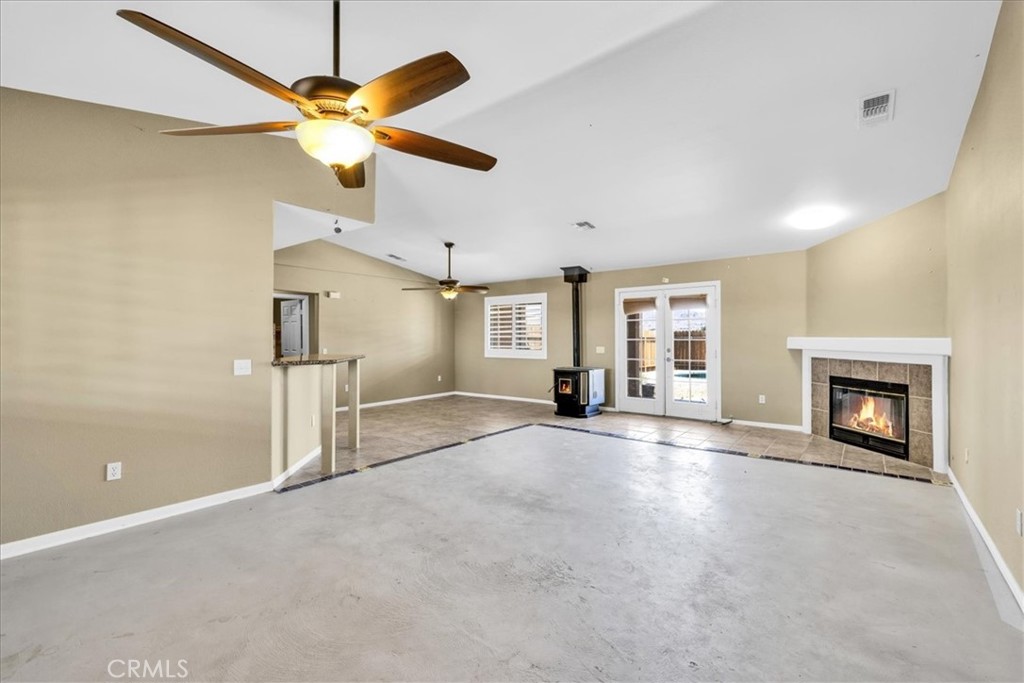 63357 Uranium Road Joshua Tree, CA 92252 - Photo 13 of 54 a view of a livingroom with a fireplace and a ceiling fan