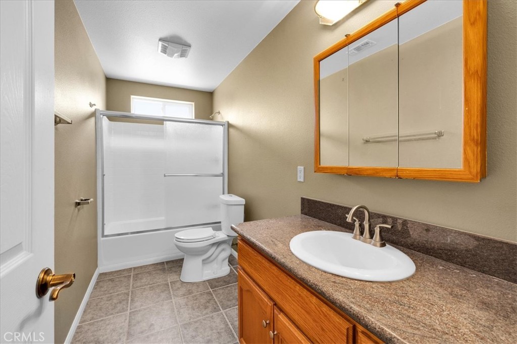 63357 Uranium Road Joshua Tree, CA 92252 - Photo 25 of 54 a bathroom with a granite countertop sink toilet and a mirror