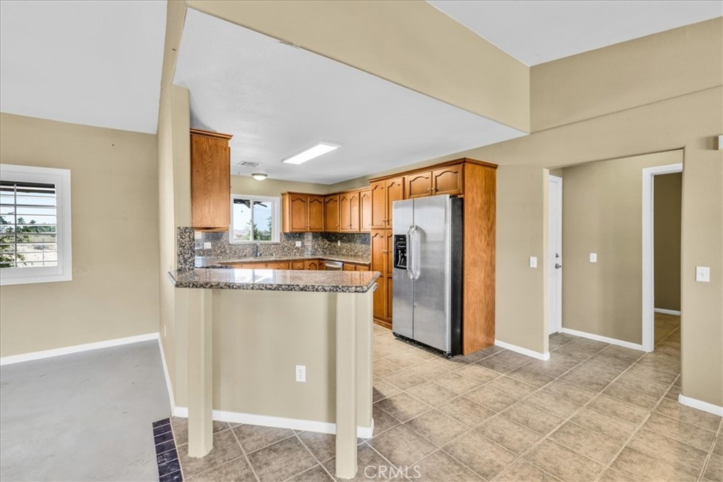 63357 Uranium Road Joshua Tree, CA 92252 - Photo 6 of 54 a kitchen with stainless steel appliances granite countertop a refrigerator and a sink