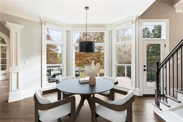 a view of a hallway with wooden floor staircase and a living room