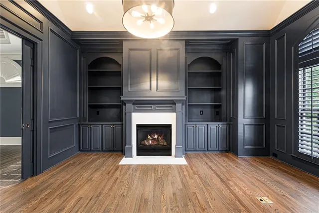 a view of a livingroom with a fireplace wooden floor and window