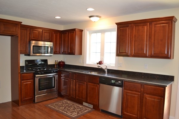 4 Waxen Way Shirley, MA 01464 - Photo 4 of 12 a kitchen with stainless steel appliances granite countertop wooden cabinets and a stove top oven