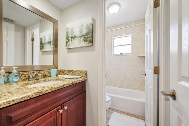 a bathroom with a granite countertop sink and a mirror