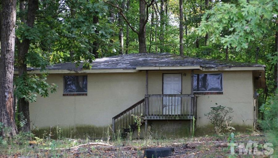 7808 Russell Road Durham, NC 27712 - Photo 1 of 8 a house that has a tree in it with wooden fence