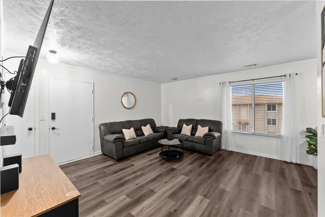 a living room with furniture and a wooden floor