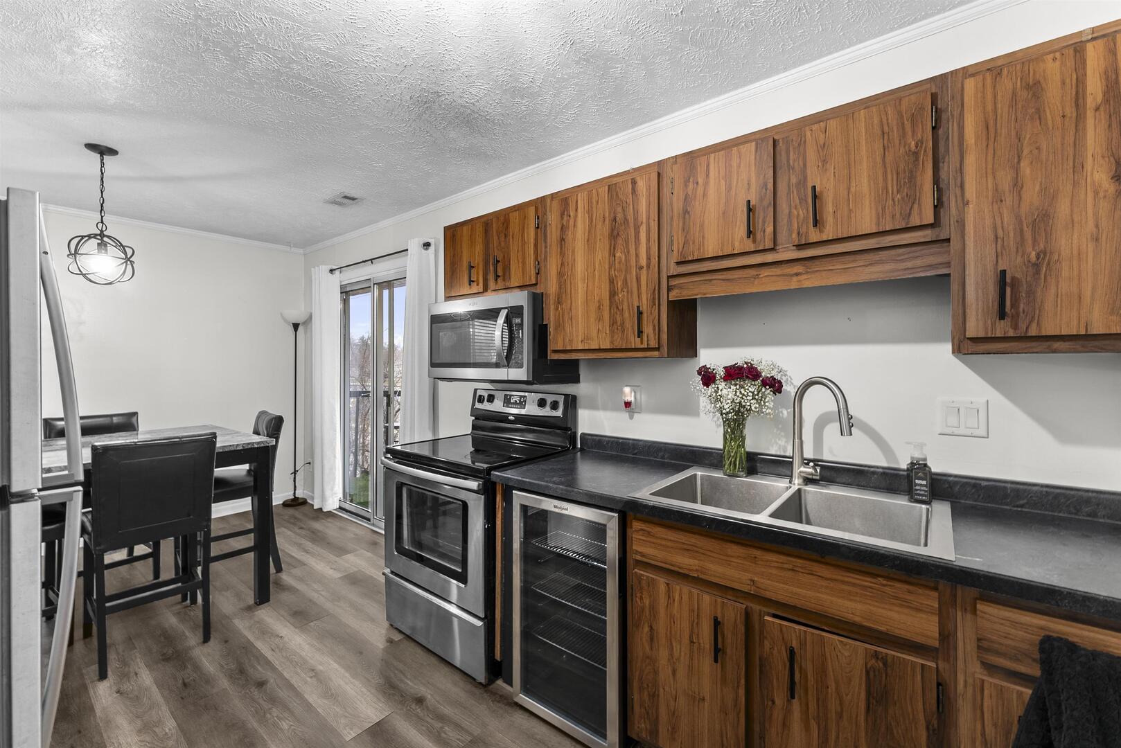1808 53rd Street, Unit 5 Moline, IL 61265 - Photo 6 of 14 a kitchen with stainless steel appliances granite countertop a sink a stove a refrigerator cabinets and dining table