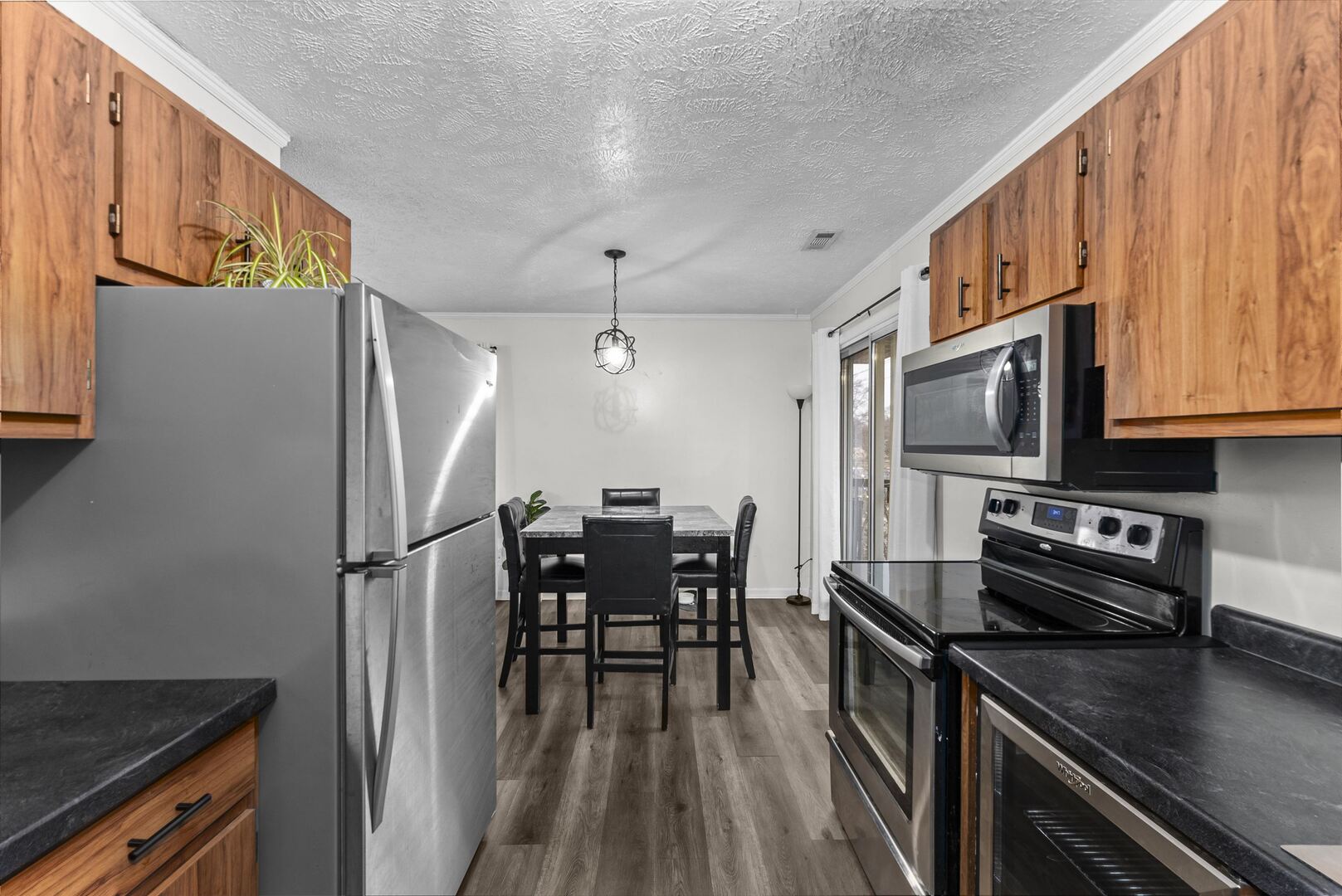 1808 53rd Street, Unit 5 Moline, IL 61265 - Photo 7 of 14 a kitchen with stainless steel appliances a refrigerator a stove a sink a dining table and chairs with wooden floor