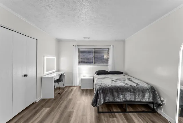 a bedroom with a bed and wooden floor