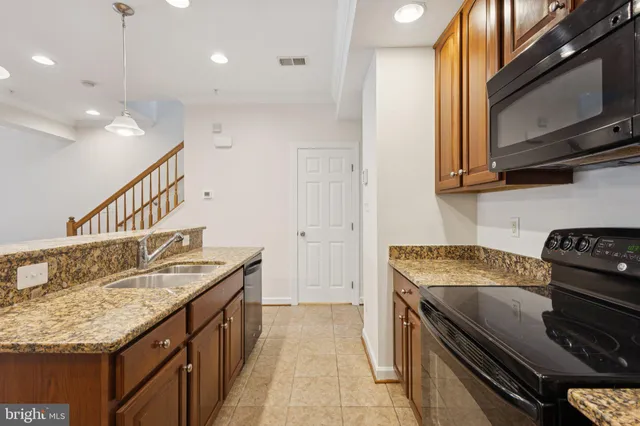 a kitchen with stainless steel appliances granite countertop a sink and a refrigerator