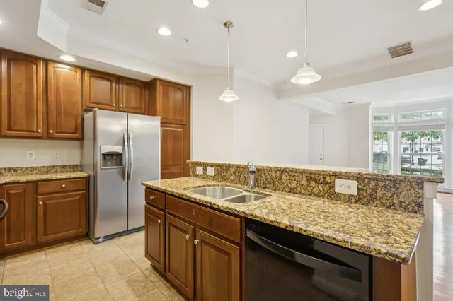 a kitchen with granite countertop cabinets stainless steel appliances and a counter space