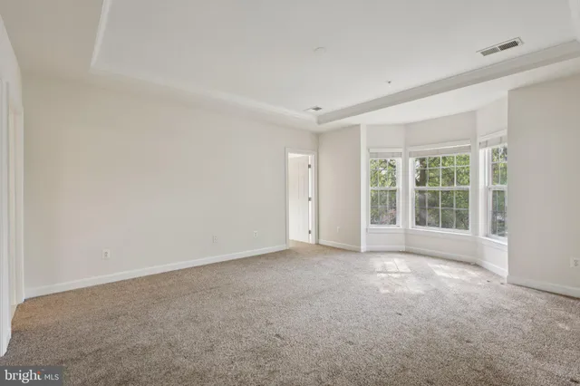 a bedroom with a bed a painting on the wall and dresser