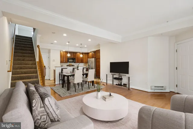 a view of a livingroom with wooden floor and stairs