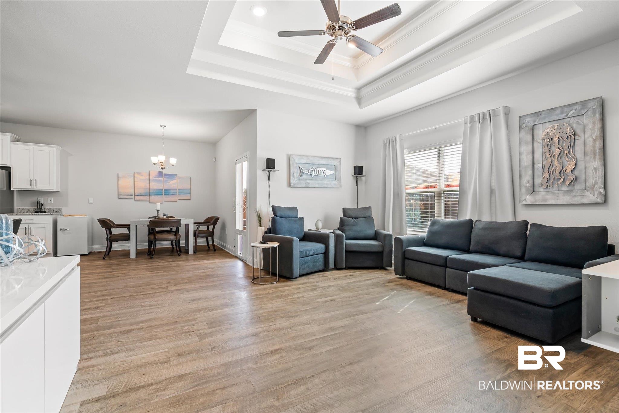 23246 Lieutenant Avenue Foley, AL 36535 - Photo 9 of 36 Living room featuring ceiling fan with notable chandelier, light hardwood / wood-style flooring, ornamental molding, and a raised ceiling