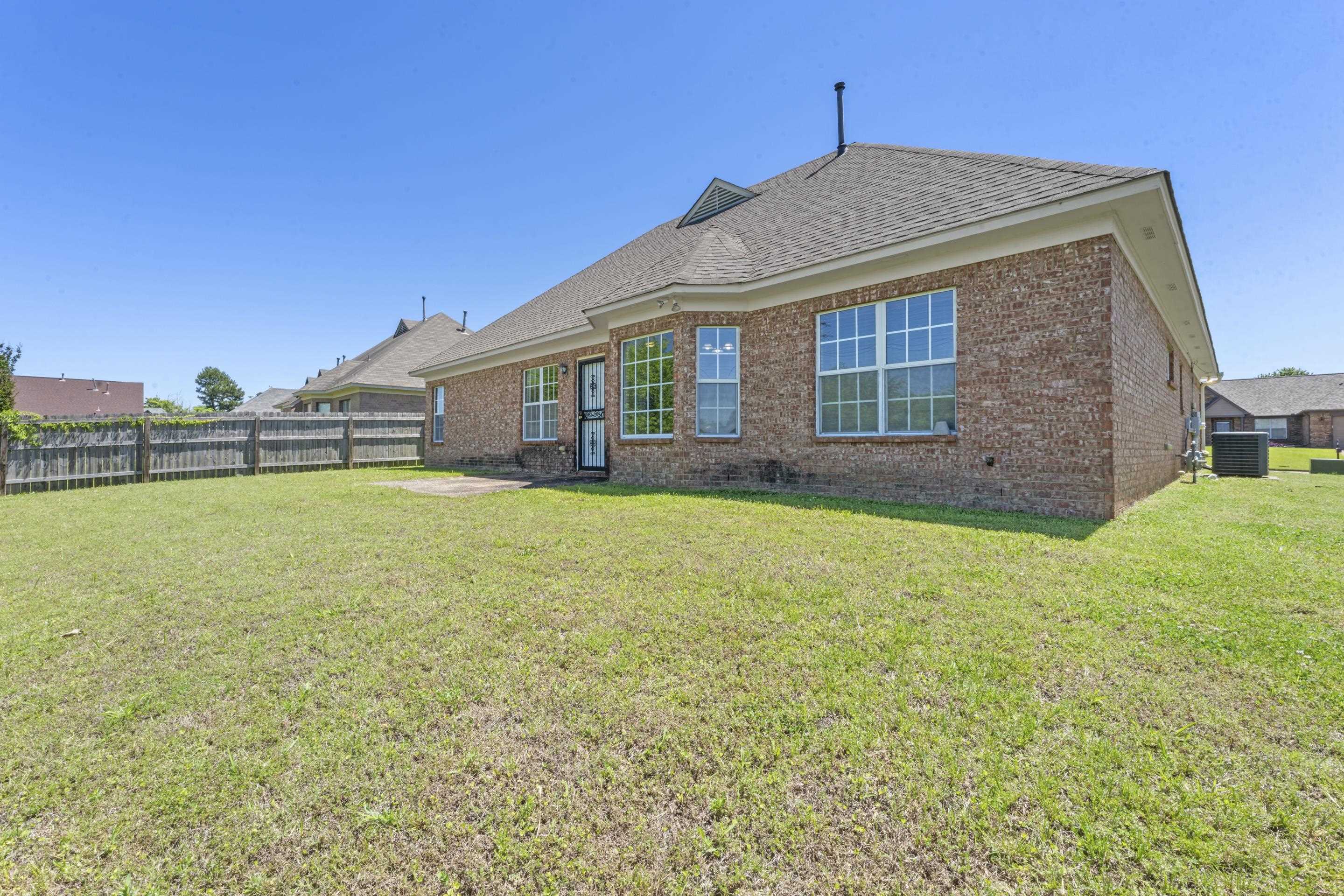 50 Abbey Road Oakland, TN 38060 - Photo 26 of 26 Expansive fenced backyard featuring a brick exterior, multiple windows, and a patio area
