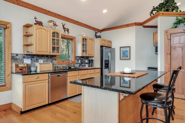 a kitchen with stainless steel appliances granite countertop a stove and cabinets