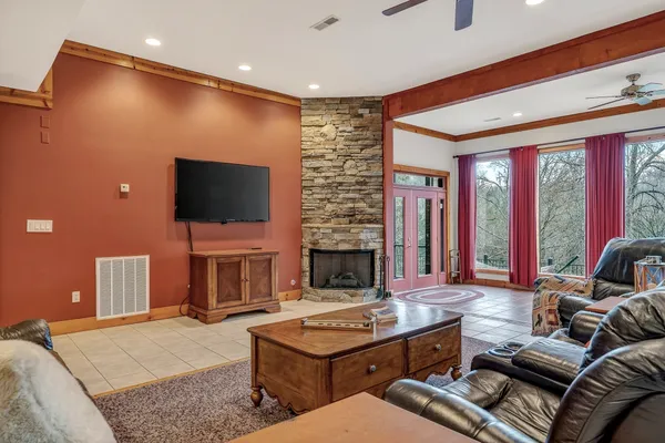 a living room with furniture a ceiling fan and a flat screen tv