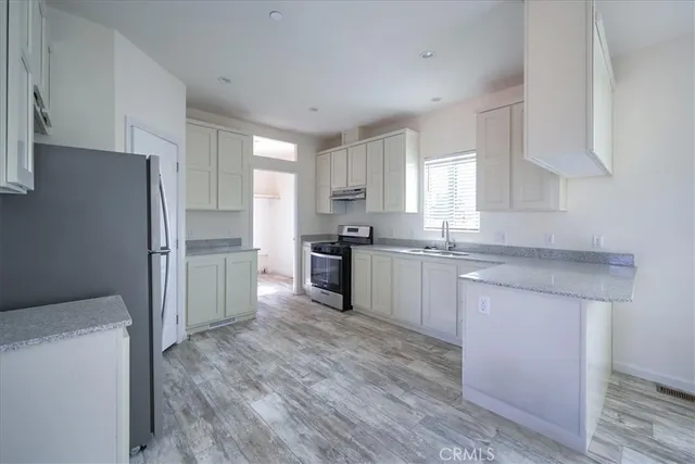 a kitchen with granite countertop a refrigerator and a sink