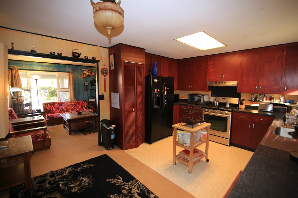 3378 Hailima Road Koloa, HI 96756 - Photo 1 of 8 a kitchen with stainless steel appliances granite countertop a stove refrigerator and dining table with wooden floor