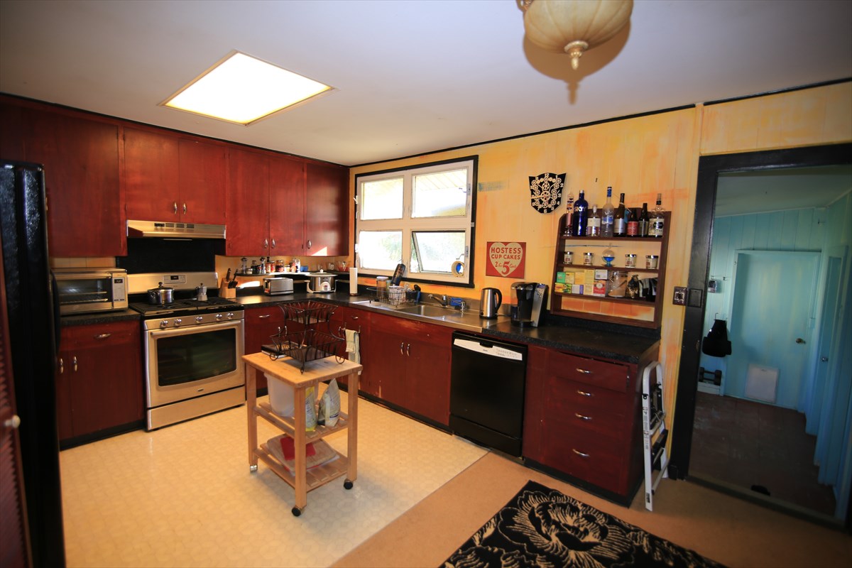 3378 Hailima Road Koloa, HI 96756 - Photo 4 of 8 a kitchen with a sink appliances dining table and chairs