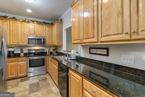 a kitchen with stainless steel appliances granite countertop a sink a stove cabinets and wooden floor