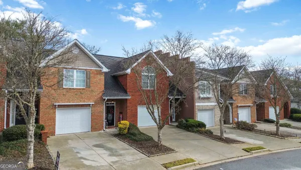 a front view of a house with a tree