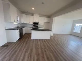 a kitchen with granite countertop a sink and a stove top oven