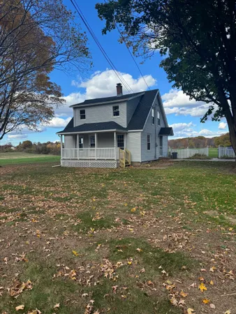a white house sitting in middle of a field