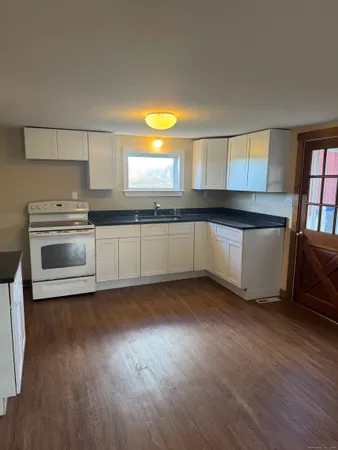 a kitchen with stainless steel appliances a sink cabinets and wooden floor