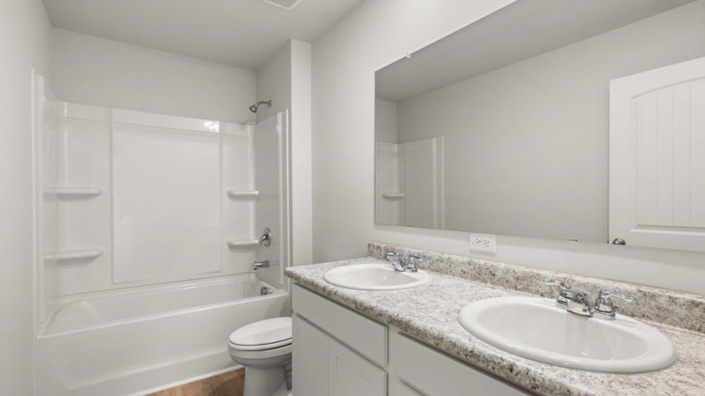 517 Oak View Lane Dallas, GA 30157 - Photo 33 of 41 a bathroom with a granite countertop sink a toilet a mirror a bathtub and shower