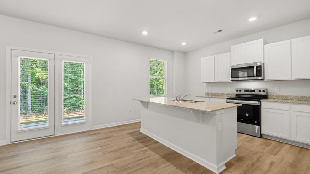517 Oak View Lane Dallas, GA 30157 - Photo 5 of 41 a kitchen with stainless steel appliances granite countertop a stove a sink dishwasher a refrigerator and a microwave oven with wooden floor