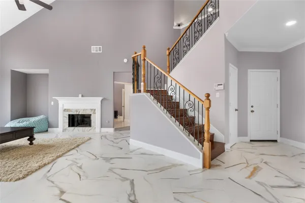 a view of a livingroom with wooden floor fireplace and stairs