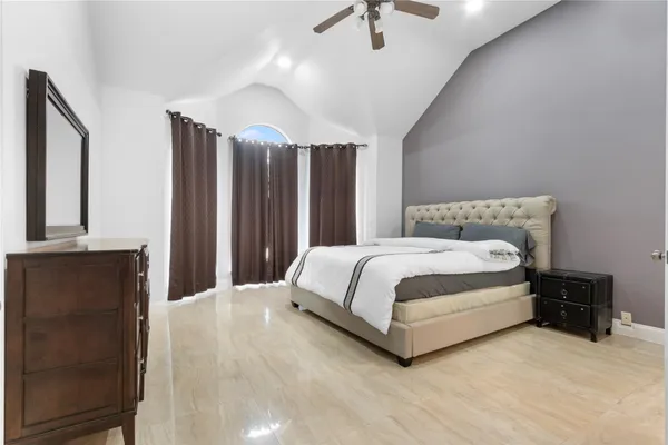 a bed sitting in a bedroom next to a bathroom with a sink and a mirror