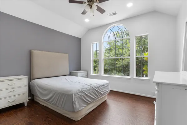 a bedroom with a large bed and a chandelier