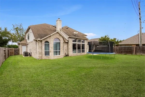 a view of a big house with a big yard and large trees