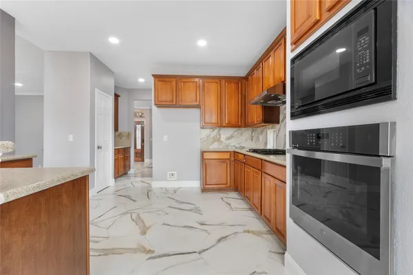 a kitchen with stainless steel appliances granite countertop a refrigerator and a stove top oven
