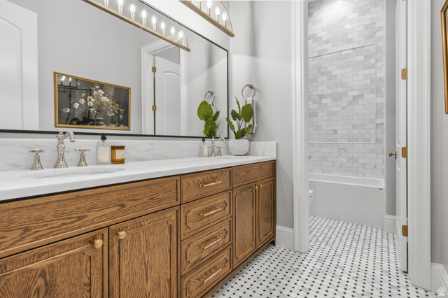 115 East Hidden Ridge Lane, Unit 42 Mapleton, UT 84664 - Photo 69 of 103 Spacious vanity featuring a long marble countertop with dual integrated sinks, rich wood cabinetry, and a full-width mirror