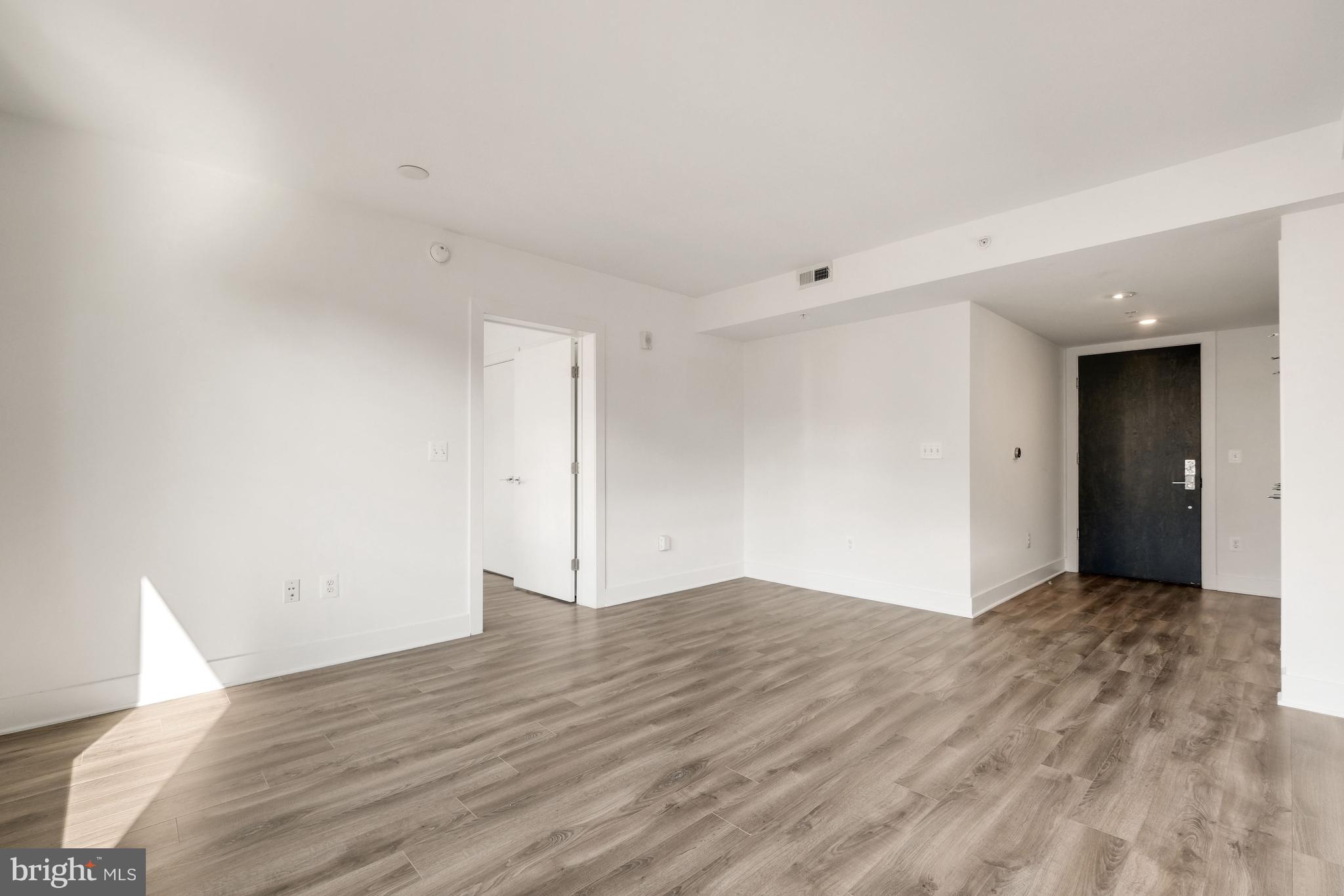 1311 13th Street Northwest, Unit 409 Washington, DC 20005 - Photo 12 of 25 a view of an empty room with wooden floor and closet