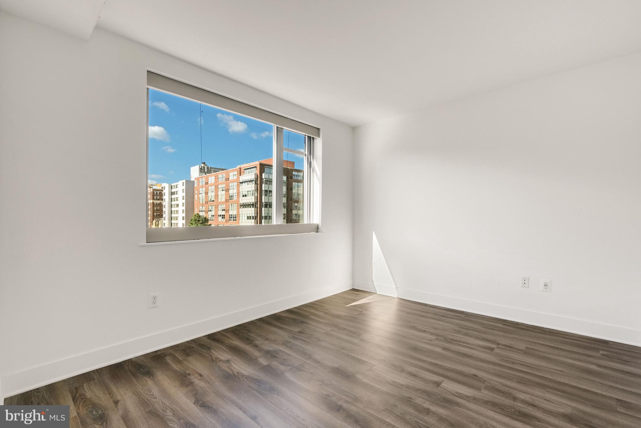 1311 13th Street Northwest, Unit 409 Washington, DC 20005 - Photo 13 of 25 an empty room with wooden floor and windows