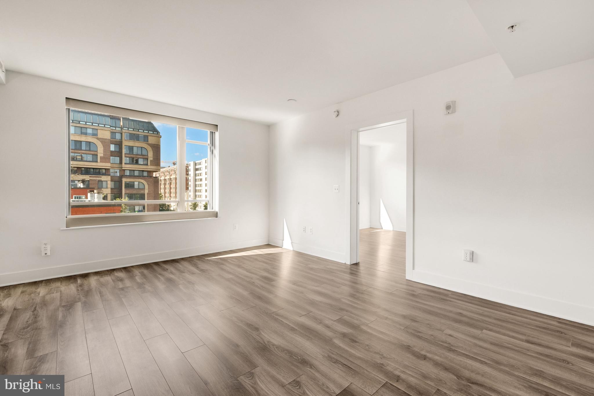 1311 13th Street Northwest, Unit 409 Washington, DC 20005 - Photo 6 of 25 a view of an empty room with wooden floor and a window