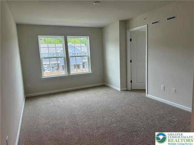 an empty room with windows and closet