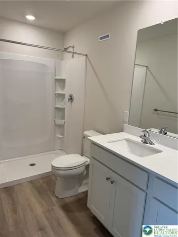 a bathroom with a sink a toilet and shower