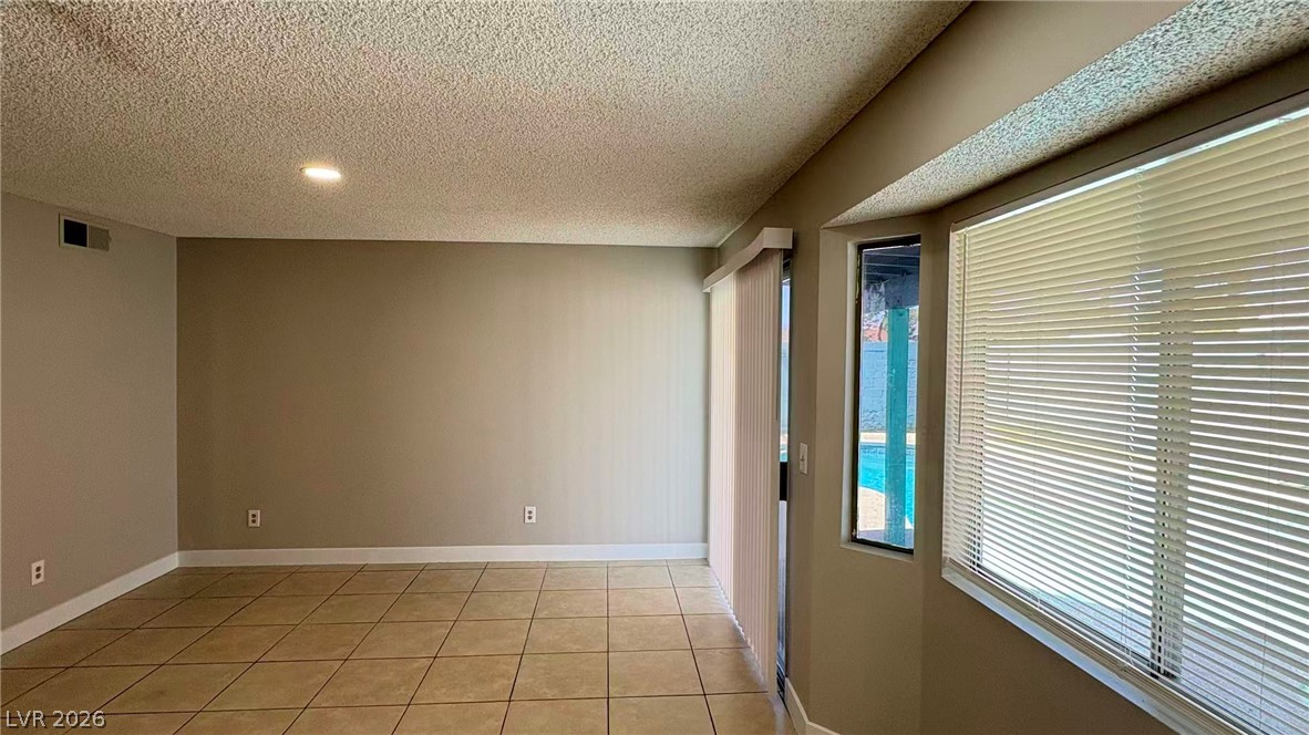 4325 Newcastle Road Las Vegas, NV 89103 - Photo 8 of 18 The open living area features tiled flooring, recessed lighting, and a view of the inviting pool.