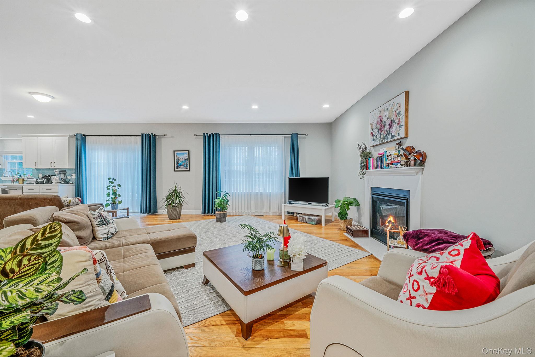152 Wood Road Centereach, NY 11720 - Photo 11 of 35 a living room with furniture fireplace and a flat screen tv