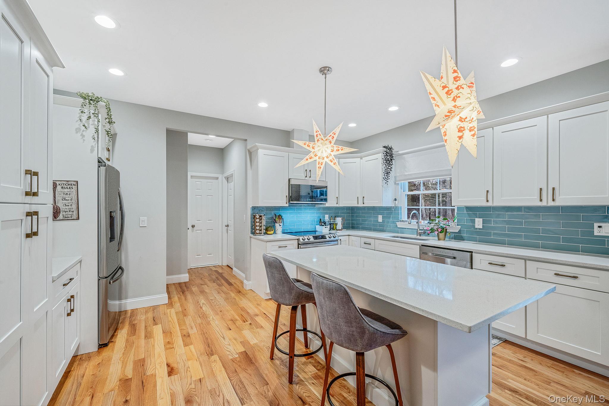 152 Wood Road Centereach, NY 11720 - Photo 14 of 35 a kitchen with stainless steel appliances granite countertop a sink a stove a refrigerator and island with wooden floor