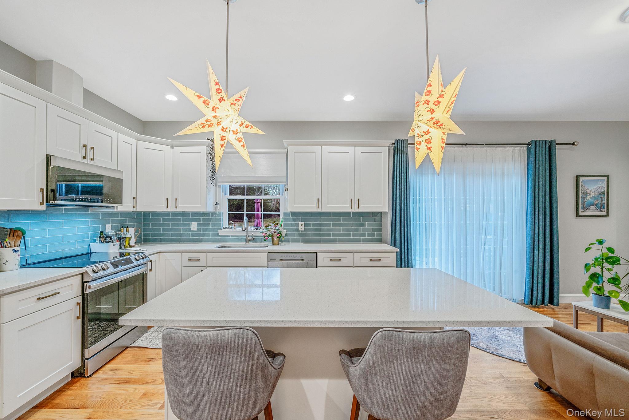 152 Wood Road Centereach, NY 11720 - Photo 15 of 35 a kitchen with stainless steel appliances granite countertop a sink a stove a dining table and chairs